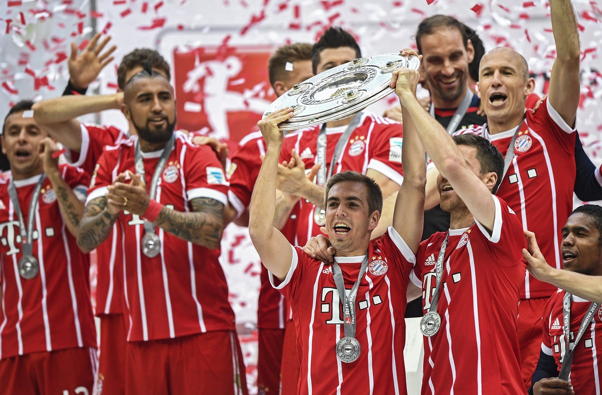 epa05976869 Bayern Munich's Philipp Lahm (C) and Xabi Alonso (R) lift the trophy for the winning German Bundesliga championship after their very final German Bundesliga soccer match between FC Ba ...