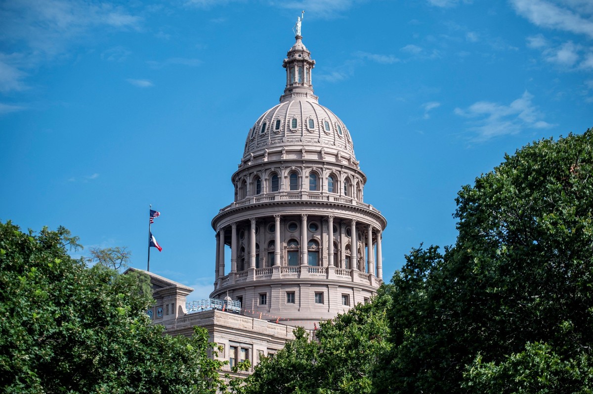 The U.S. and Texas State flags fly at the Texas Capitol building during a session as lawmakers vote on various bills addressing funding for flood relief and prevention in response to the July 4 floods ...