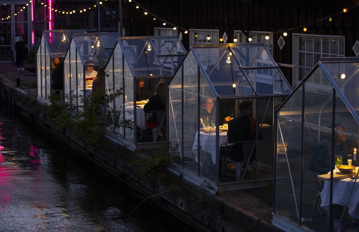 FILE - In this May 5, 2020 file photo, staff at the Mediamatic restaurant serve food to volunteers seated in small glasshouses during a try-out of a setup which respects social distancing abiding by g ...