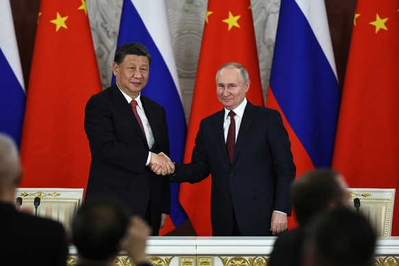 Russian President Vladimir Putin, right, and Chinese President Xi Jinping shake hands after speaking to the media during a signing ceremony following their talks at The Grand Kremlin Palace, in Moscow ...