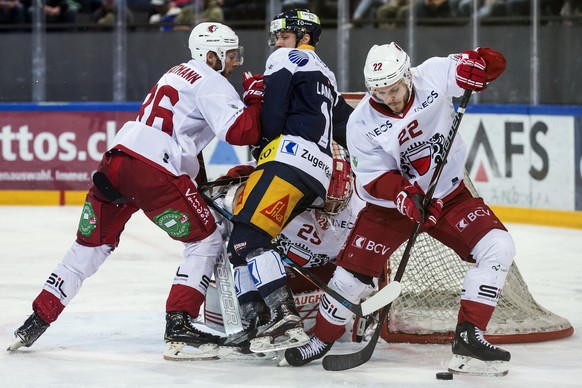 Lausannes Dario Trutmann, links, und Lausannes Christoph Bertschy, rechts, im Spiel gegen Zugs Dominic Lammer, Mitte, im Eishockey Meisterschaftsspiel der National League zwischen dem EV Zug und Lausa ...