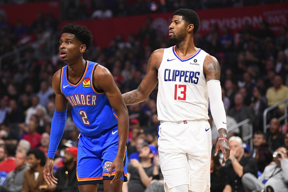 LOS ANGELES, CA - NOVEMBER 18: Oklahoma City Thunder Guard Shai Gilgeous-Alexander 2 and Los Angeles Clippers Guard Paul George 13 and look on during a NBA, Basketball Herren, USA game between the Okl ...