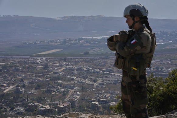 A French U.N. peacekeeper stands on a hill overlooking Kfar Kila, a Lebanese border village destroyed by Israeli airstrikes and a ground offensive, in south Lebanon, Wednesday, Aug. 20, 2025. (AP Phot ...