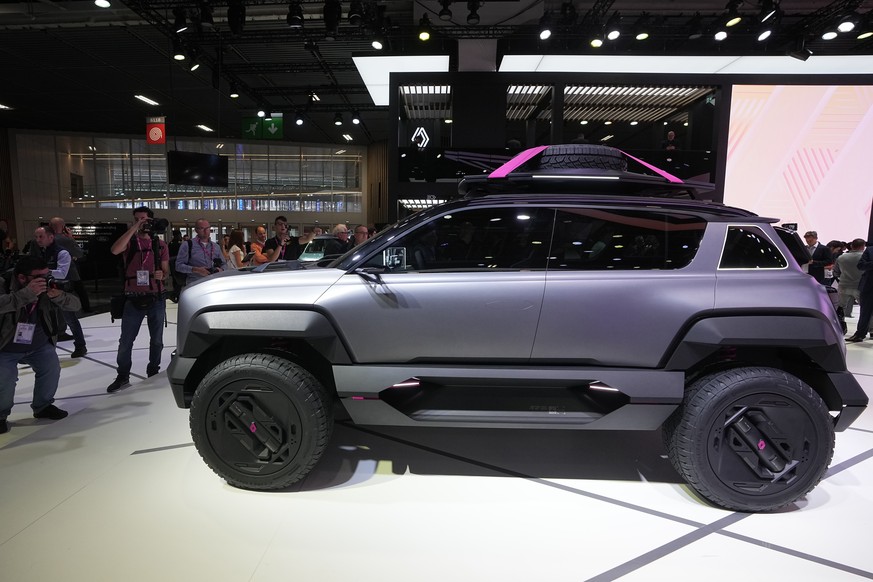 Visitors gather around the Renault 4Ever Trophy electric SUV concept car at the Paris Car Show Monday, Oct. 17, 2022 in Paris. Europe is leading the charge into electric vehicles as battery powered ca ...