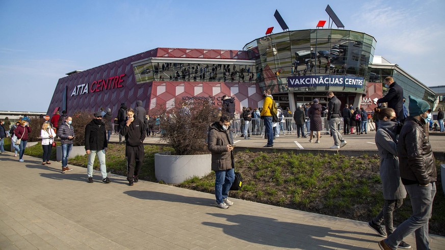 210417 -- RIGA, April 17, 2021 -- People line up to enter a mass immunization center for COVID-19 in Riga, Latvia, on April 16, 2021. Latvia on Friday opened a mass immunization center for non-priorit ...