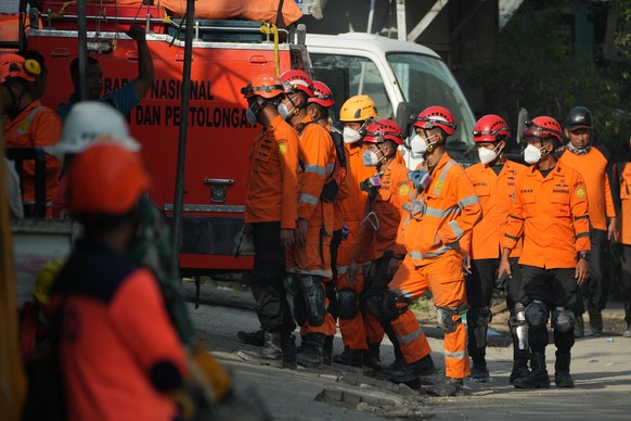 Rescuers gather outside the islamic boarding school where a building collapsed as the search for missing people is underway in Sidoarjo, East Java, Indonesia, Saturday, Oct. 4, 2025. (AP Photo/Achmad  ...