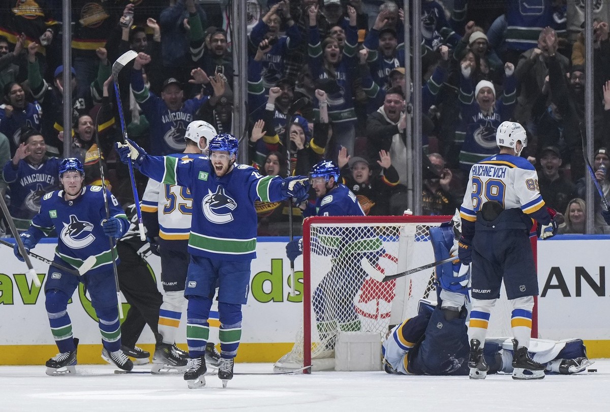 Vancouver Canucks' Pius Suter and Brock Boeser, left, celebrate Suter's third goal of the night, against St. Louis Blues goalie Joel Hofer, back right, as Pavel Buchnevich (89) stands next t ...