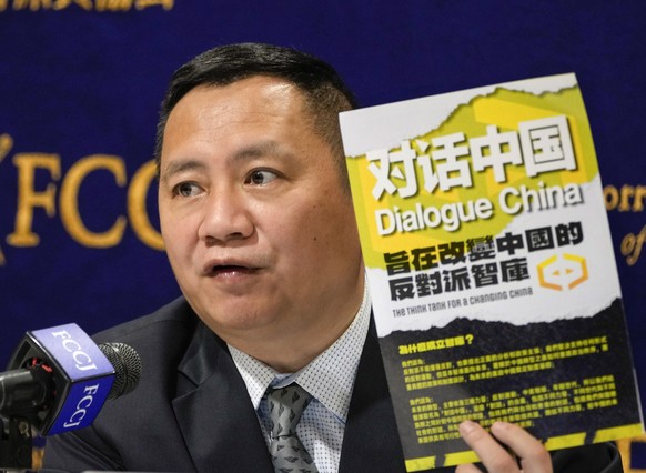 epa10340905 Wang Dan, a prominent former student leader of the 1989 Tiananmen Square democracy movement, and director of Dialogue China, with his book while speaking at the Foreign Correspondents' Club...