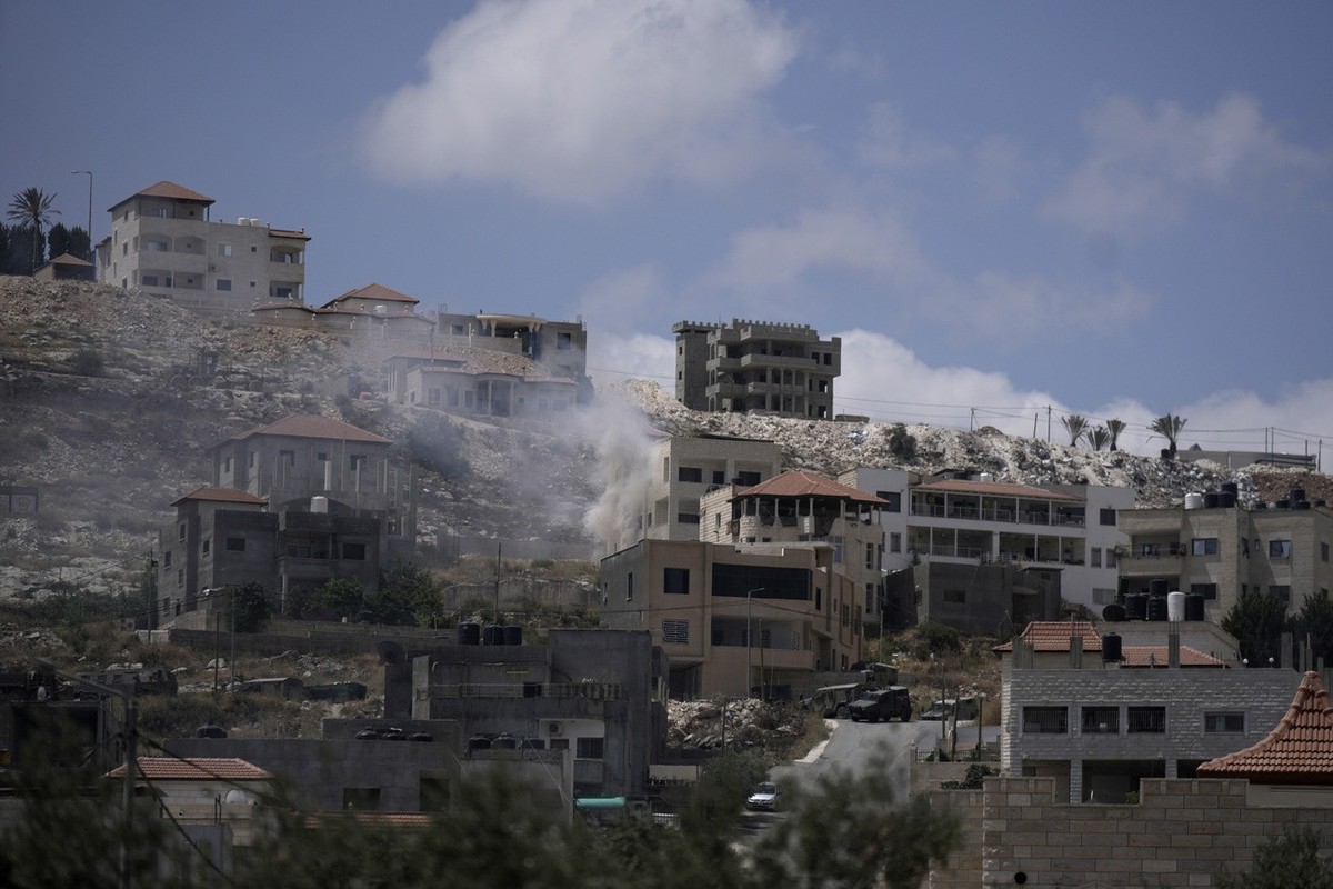 Smoke rises from fighting between Israeli forces and Palestinian militants in the West Bank city of Jenin Monday, June 19, 2023. Israeli helicopter gunships struck targets in the West Bank, during a f ...