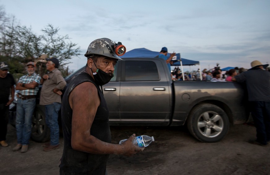 epa09248841 Miners await for information about their colleagues after the flooding and the collapse of a mine in the municipality of Muzquiz, Coahuila state, Mexico, 04 June 2021. At least seven miner ...