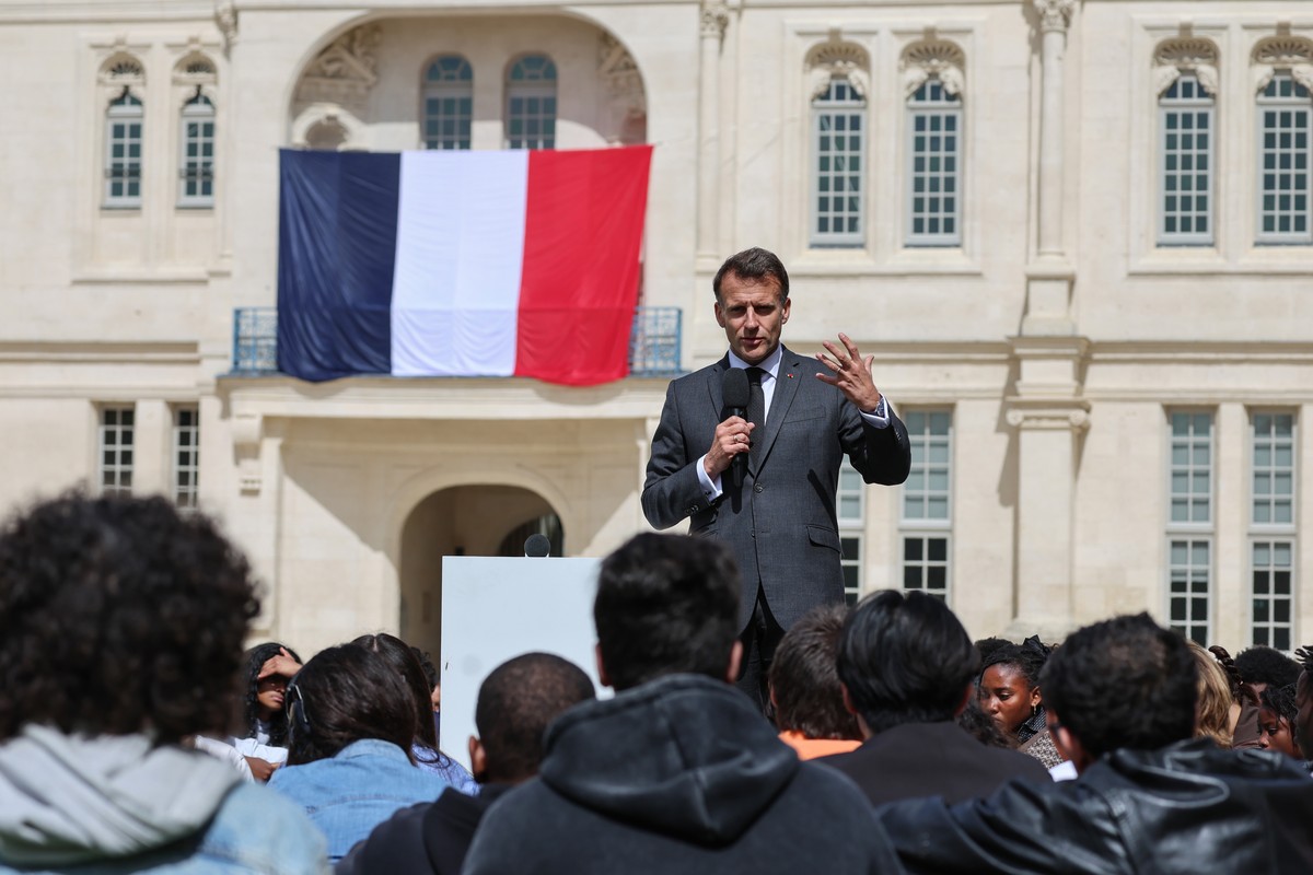 epa12893626 France's President Emmanuel Macron delivers a speech with a French flag in the background during his visit to the International City of French Language (Cite Internationale de la Lang ...