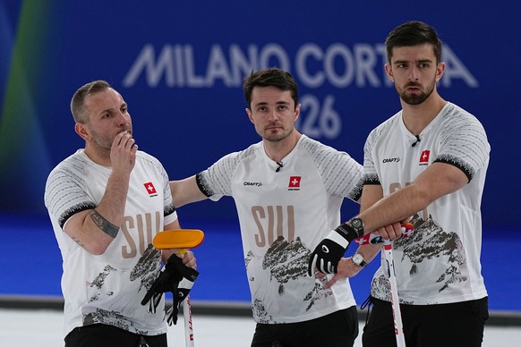 Switzerland's Benoit Schwarz-van Berkel, Sven Michel and Pablo Lachat-Couchepin watch action in a men's curling semifinal match against Britain at the 2026 Winter Olympics, in Cortina d' ...