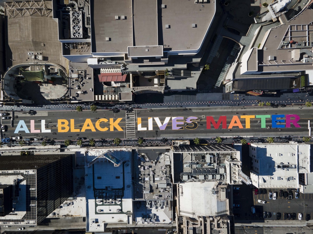 epaselect epa08484062 A photo taken with a drone shows people painting an 'All Black Lives Matter' mural on Hollywood Boulevard in Hollywood, California, USA, 13 June 2020. An eyewitness vid ...