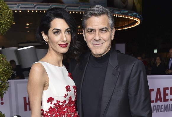 FILE - In this Feb. 1, 2016 file photo, Amal Clooney, left, and George Clooney arrive at the world premiere of &quot;Hail, Caesar!&quot; in Los Angeles. George and Amal Clooney have welcomed twins Ell ...
