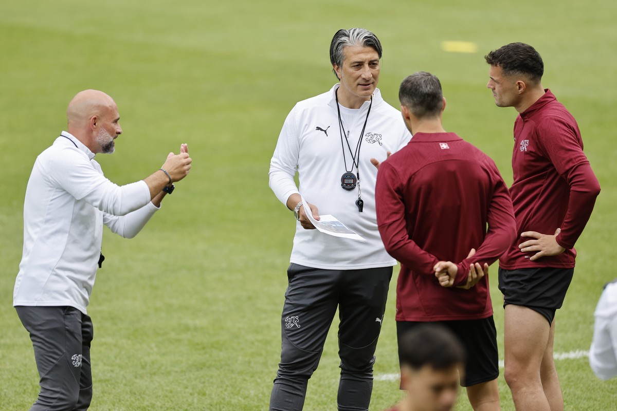 Switzerland's assistant coach Giorgio Contini, head coach Murat Yakin, Remo Freuler and Granit Xhaka, from left, discuss during a training session at the "Stadion auf der Waldau" in Stu ...