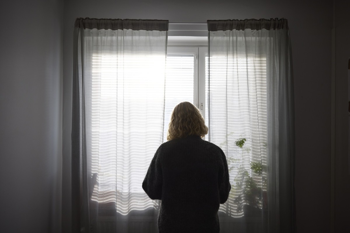 Rear view of teenage girl looking through window