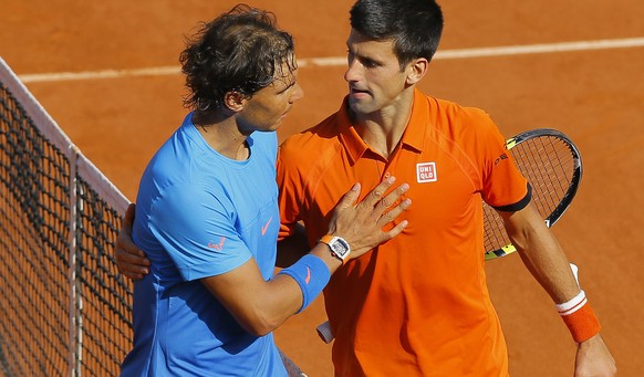 epa04781905 Novak Djokovic of Serbia (R) hugs after winning against Rafael Nadal of Spain during their quarterfinal match for the French Open tennis tournament at Roland Garros in Paris, France, 03 Ju ...