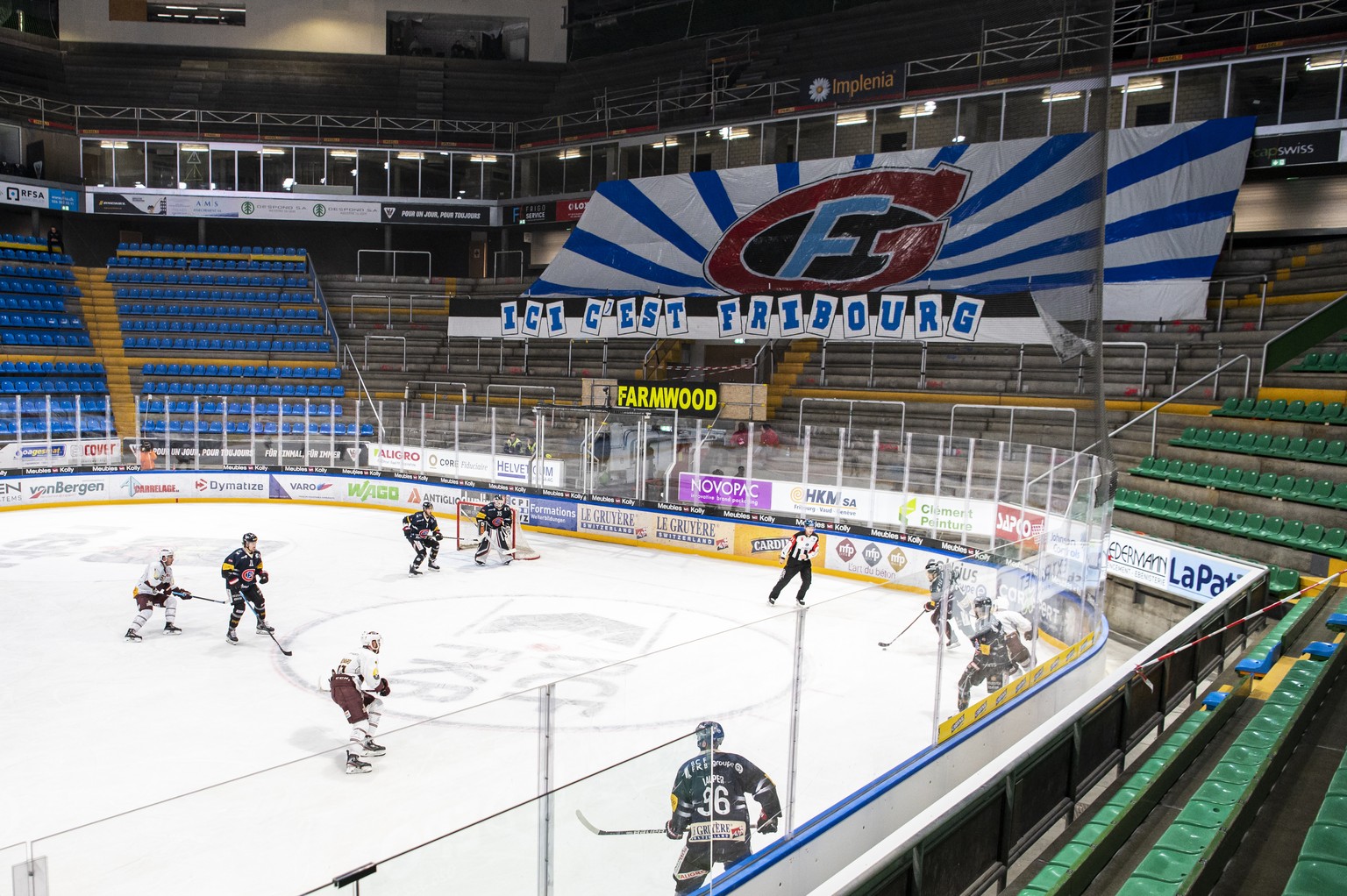 Les joueurs fribourgeois et genevois s'affrontent dans une patinoire vide suite aux mesures prises par le Conseil Federal en raison du coronavirus, lors de la rencontre du championnat suisse de hockey ...