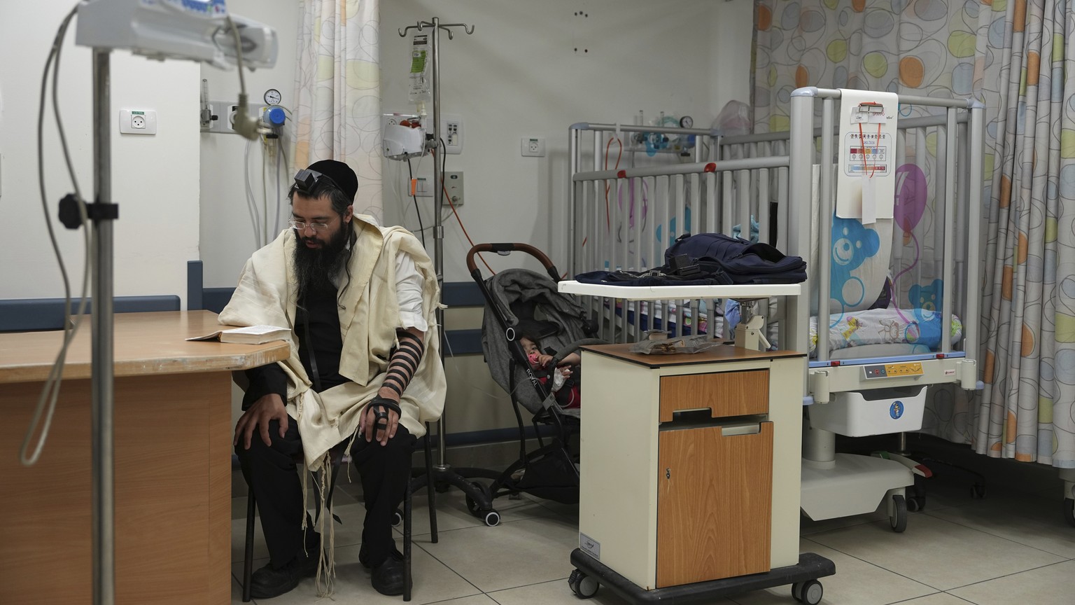 An ultra-Orthodox Jewish man prays in a protected area housing pediatric patients at Barzilai Hospital in Ashkelon, southern Israel, under threat of rockets fired from the Gaza Strip after Israel kill ...