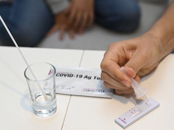 FILE - A mother tests her daughter with a Corona antigen self-test before starting school in Trencianske Stankovce, Slovakia, Oct. 4, 2021. New coronavirus cases soared to a new record high, with some ...