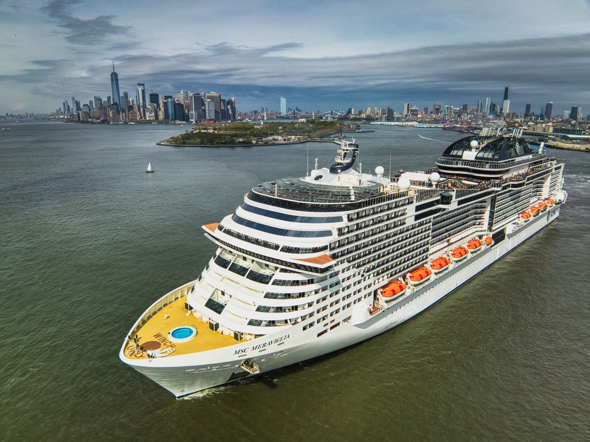 RECORD DATE NOT STATED A modern MSC cruise ship sailing in a tranquil sea with a bustling city skyline in the background *** einer Modernes MSC T