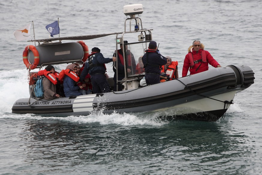 FILE - Migrants sit on a Cyprus marine police boat as they are safely brought to a harbor after being rescued from their own vessel off the Mediterranean island nation&#039;s southeastern coast, of Pr ...