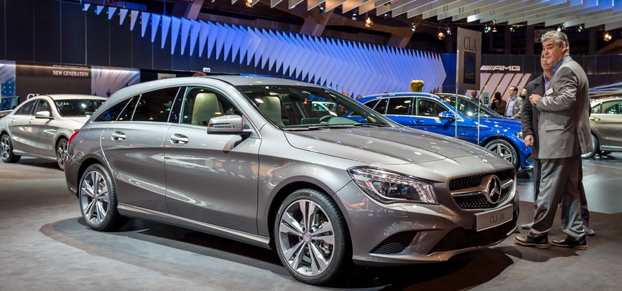 Men look at the Mercedes CLA Shooting Break during the media day of the 93rd European Motor Show in Brussels on Thursday, Jan. 15, 2015. (AP Photo/Geert Vanden Wijngaert)