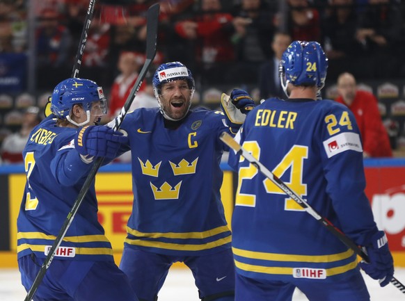 Sweden&#039;s Alexander Edler, right, celebrates with Joel Lundqvist, center, and John Klingberg, left, after scoring a goal during the Ice Hockey World Championships quarterfinal match between Switze ...