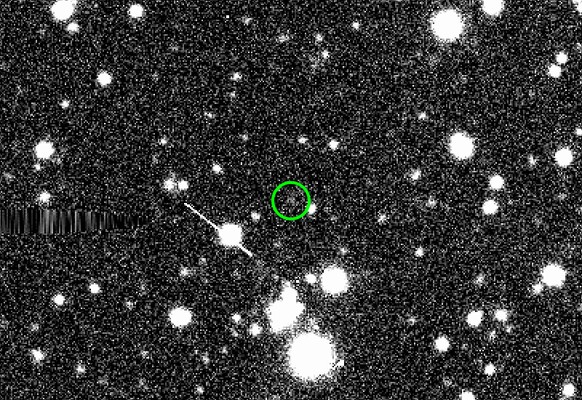 The sednoid 2023 KQ14 (in green circle) imaged by the Victor M. Blanco&#039;s Dark Energy Camera on 7 June 2021. Surrounding white fuzzy circles are background stars and white fuzzy smudges and ellips ...