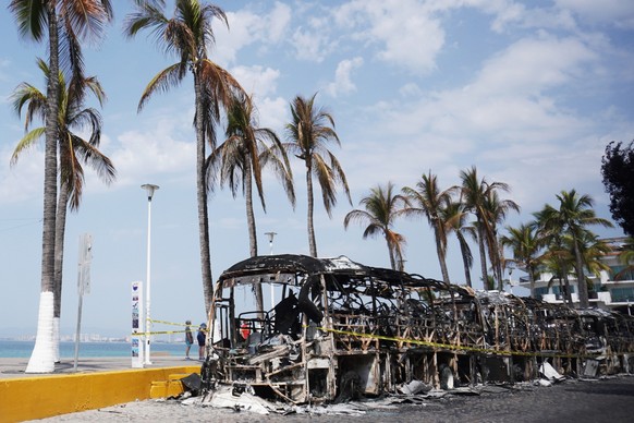 epa12772351 Burned out vehicles are seen on the boardwalk in Puerto Vallarta, Mexico, 23 February 2026. The resort city reports visible disruptions after violence linked to the killing of drug cartel  ...
