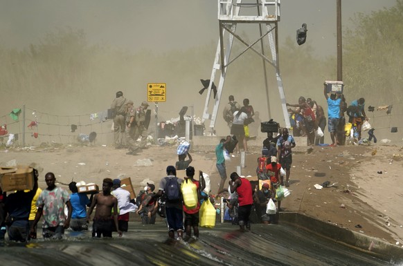 A dust storm moves across the area as Haitian migrants use a dam to cross into the United States from Mexico, Saturday, Sept. 18, 2021, in Del Rio, Texas. U.S. President Joe Biden&#039;s administratio ...