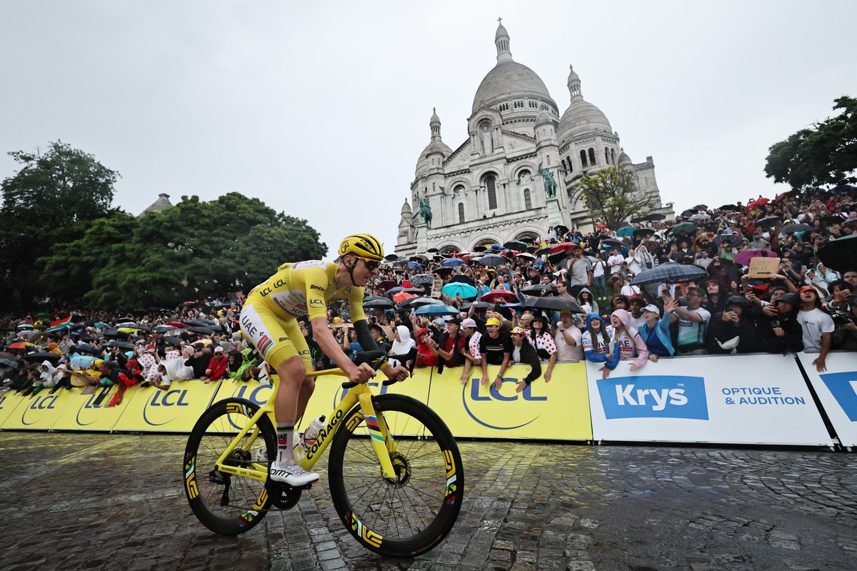 epa12266219 Slovenian rider Tadej Pogacar of UAE Team Emirates passes Sacre-Coeur during the 21st and last stage of the Tour de France cycling race over 132.3km from Mantes-la-Ville to Paris, France,  ...