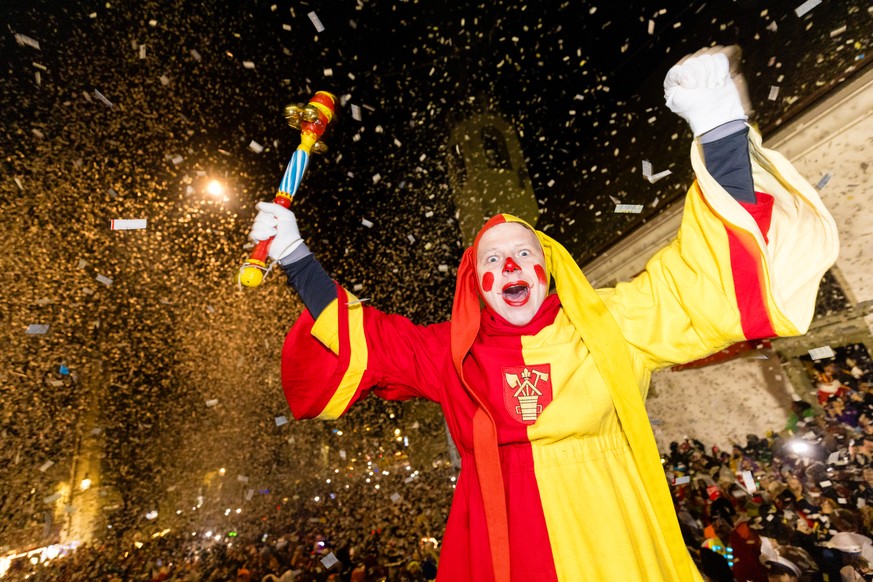 Ein Narr geniesst den &#039;Foetzeliraege&#039; auf dem Kapellplatz an der Fritschi-Tagwache der Luzerner Fasnacht am Schmutzigen Donnerstag, 27. Februar 2025 in Luzern. Die Luzerner Fasnacht dauert v ...