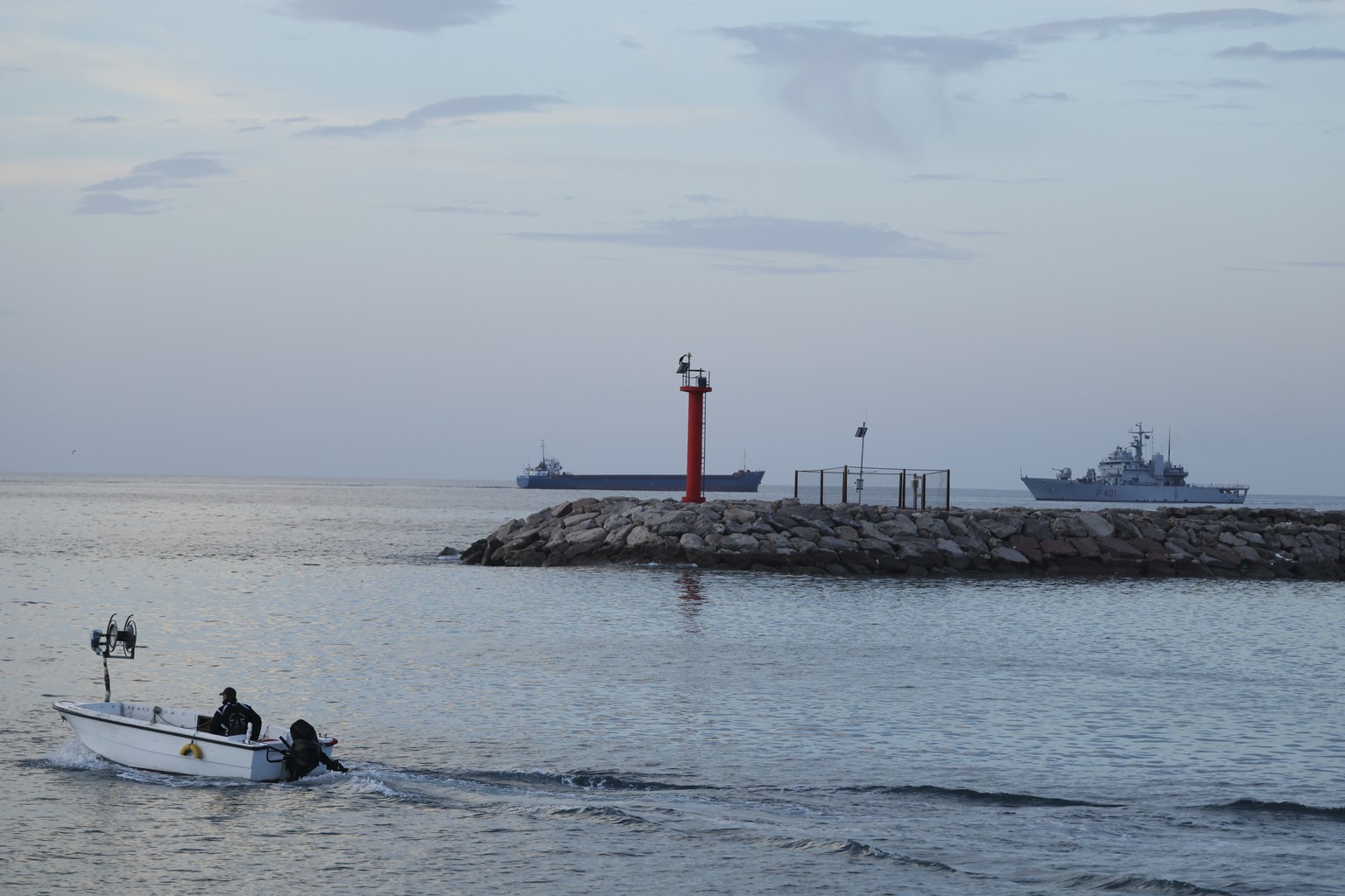 An Italian navy ship, right, with 49 migrants approaches the port, in the third such attempt following hurdles by Italian courts, in Shengjin, northwestern Albania, Tuesday, Jan. 28, 2025. (AP Photo/V ...