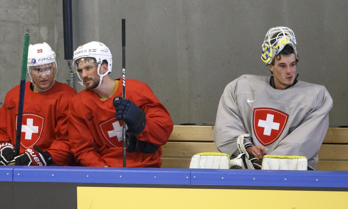 Switzerland's forward Nino Niederreiter, left, speaks with Switzerland's defender Roman Josi, 2nd left, past Switzerland's goaltender Gilles Senn, right, during a training session of th ...