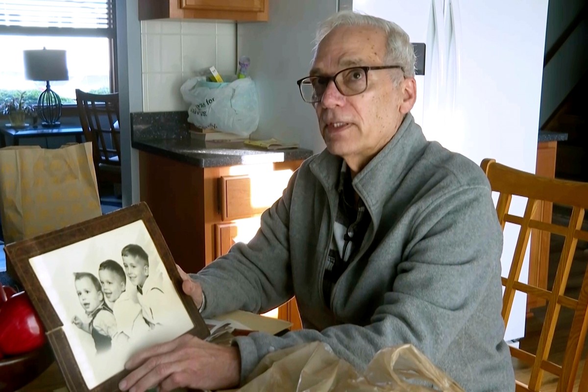FILE - John Prevost, brother of new Pope Leo XIV, holds a portrait of the three Prevost brothers from 1958, Pope Leo, 3, left, John, 4, and Louis, 7, at his home, May 8, 2025, in New Lenox, Ill. (AP P ...