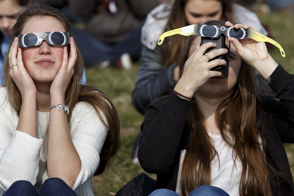People watch the spectacle of a partial solar eclipse, at the Swiss Federal Institute of technology (EPFL), in Lausanne, Switzerland, Friday, March 20, 2015. A Partial Solar Eclipse is seen today in E ...