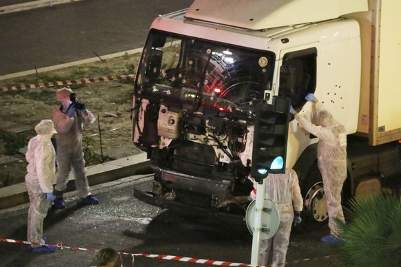 FILE - Authorities investigate a truck after it plowed through Bastille Day revelers in the French resort city of Nice, France, killing 86 people on July 14, 2016. A French court on Tuesday Dec.13, 20 ...