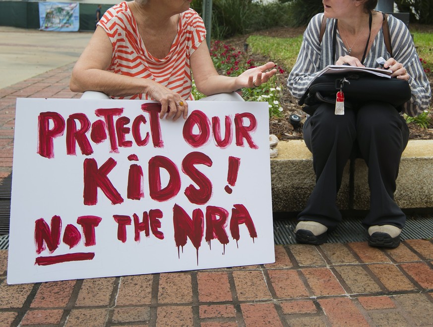 epa06550682 A woman holds a sign at the Florida state Capitol in Tallahassee, Florida, USA, 21 February 2018. Seventeen people were killed by a gunman at Marjory Stoneman Douglas High School 14 Februa ...