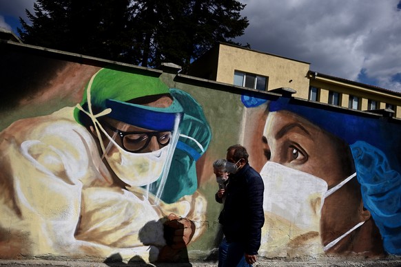 epa09123810 People pass by a graffiti depicting resuscitation doctors in a COVID-19 ward at the fence of Children&#039;s Infectious Diseases Hospital in Sofia, Bulgaria, 09 April 2021. EPA/VASSIL DONE ...