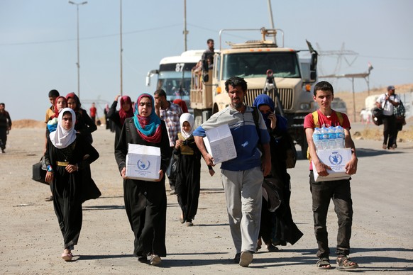 epa05969890 People carry their belonging as they flee from western Mosul, Iraq, 17 May 2017. The military offensive to retake Mosul city from the Islamic State Group (IS) is entering its final phases  ...