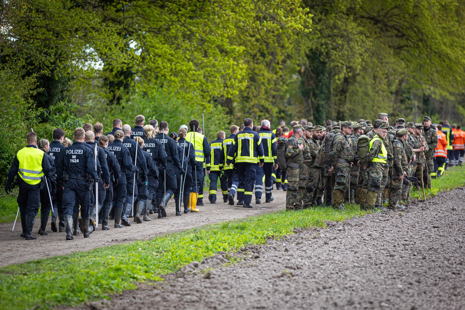 28.04.2024, Niedersachsen, Gr�pel: Einsatzkr�fte der Polizei und der Feuerwehr und Soldaten der Bundeswehr sammeln sich an einem Weg, um in der Folge ein Feld abzusuchen. Der sechs Jahre alte Arian au ...