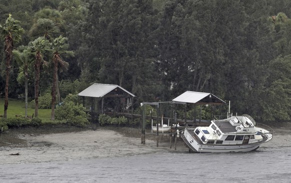 A boat rests on its side in what is normally six feet of water in Old Tampa Bay, Sunday, Sept. 10, 2017, in Tampa, Fla. Hurricane Irma, and an unusual low tide pushed water out into the Gulf of Mexico ...