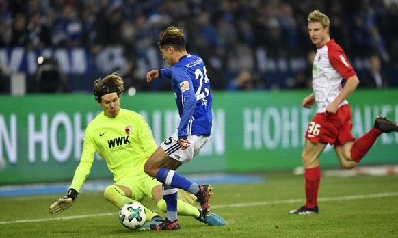 Augsburg goalkeeper Marwin Hitz fouls Schalke&#039;s Amine Harit during the German Bundesliga soccer match between FC Schalke 04 and FC Augsburg in Gelsenkirchen, Germany, Wednesday, Dec. 13, 2017. (A ...