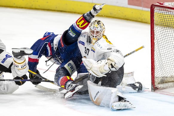 ZSC Lions Stuermer Ronalds Kenins gegen HC Lugano Torhueter Elvis Merzlikins, rechts, im sechsten Eishockey Playoff-Finalspiel der National League zwischen den ZSC Lions und dem HC Lugano am Mittwoch, ...