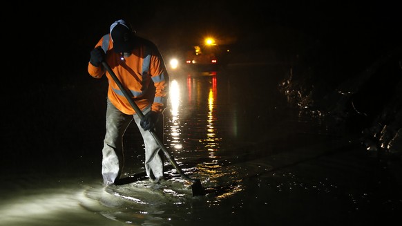 Butte County road worker Matt Brandt clears a drain pump of debris from a mudslide that partially blocked Honey Run Road, Thursday, Nov. 29, 2018, near Chico, Calif. Flash flooding hit Chico and nearb ...