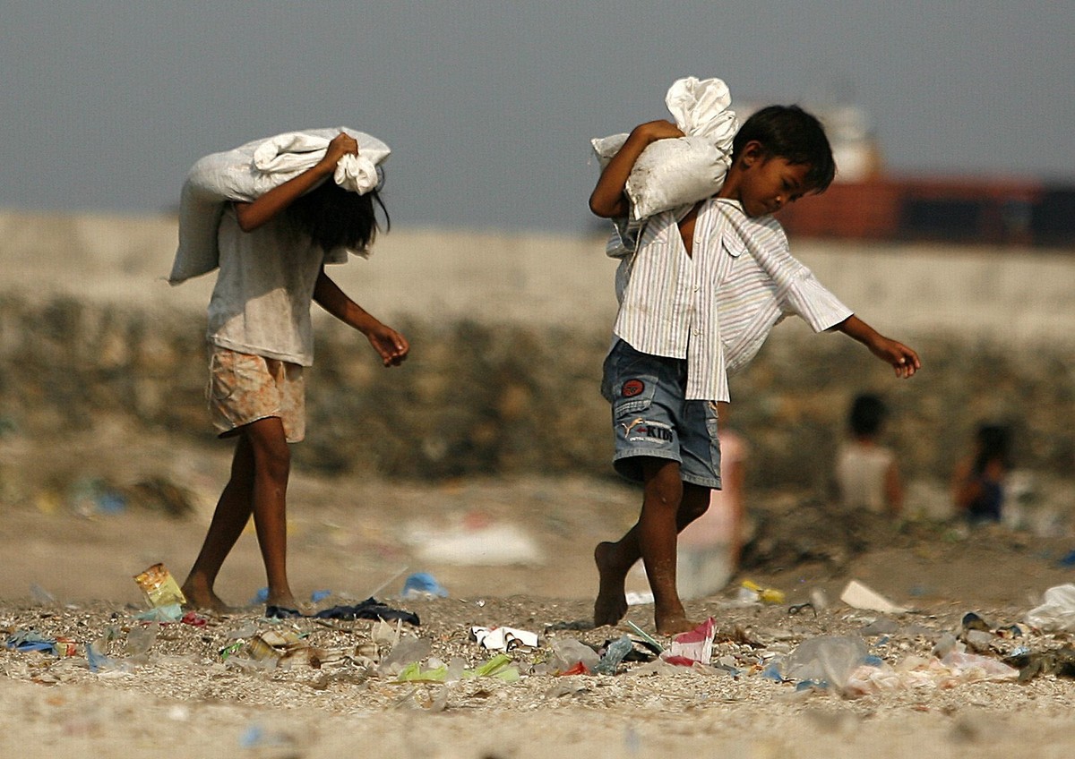 epa02129858 Filipino children work by collecting sand at a shore line in Manila suburbs, Philippines on 24 April 2010. Underage children are being forced to manual labor to help their families mainly  ...