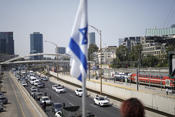 Israelis stand still next to their cars on a freeway as a two-minute siren sounds in memory of victims of the Holocaust in Tel Aviv, Israel, Thursday, April 28, 2022. Holocaust remembrance day is one  ...