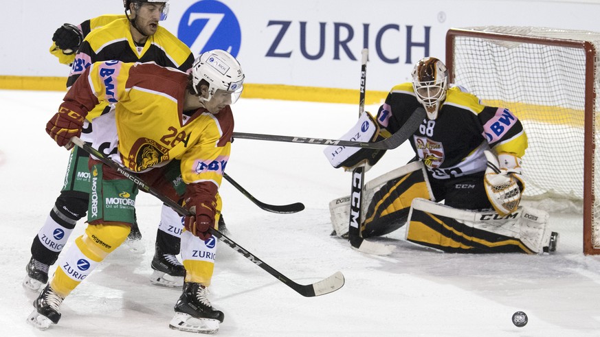 Ajoies Philip-Michael Devos, links, und Goalie Dominic Nyffeler im Kampf um den Puck gegen Tigers Yannick-Lennart Albrecht, Mitte, waehrend dem Swiss Ice Hockey Cup Viertelfinal zwischen dem HC Ajoie, ...