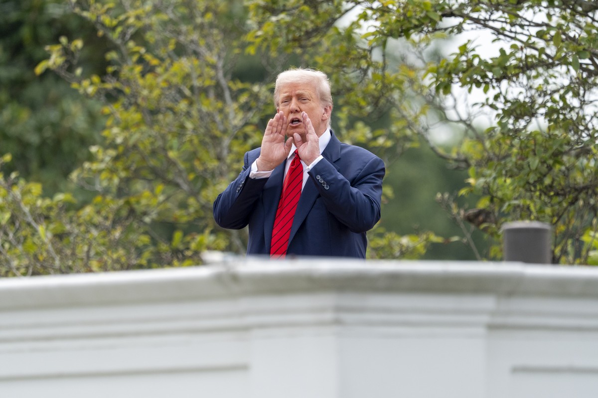 President Donald Trump shouts to reporters as he surveys the grounds from the roof above the Colonnade that goes to the West Wing of the White House, Tuesday, Aug. 5, 2025, in Washington. (AP Photo/Al ...